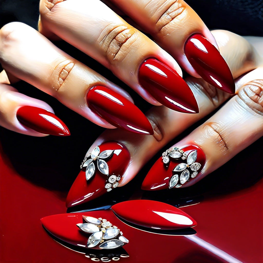 glossy red almond nails with a single rhinestone accent per finger