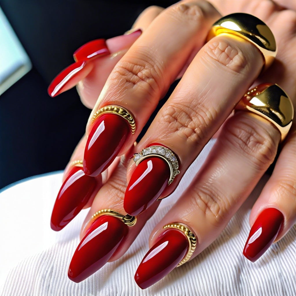 red nails with a single gold band at the cuticle
